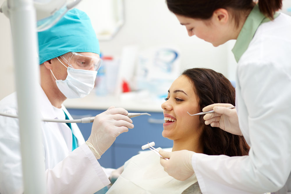 A dentist looking at a patient's teeth.